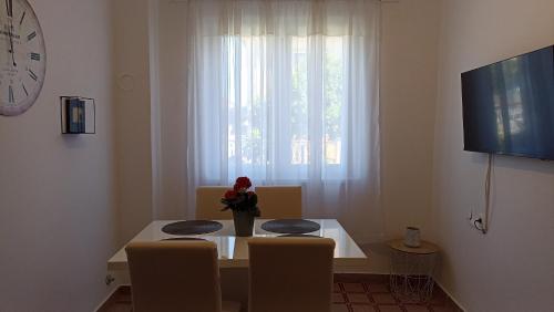 a dining room table with chairs and a vase with flowers at Great apartment Katarina in Zadar