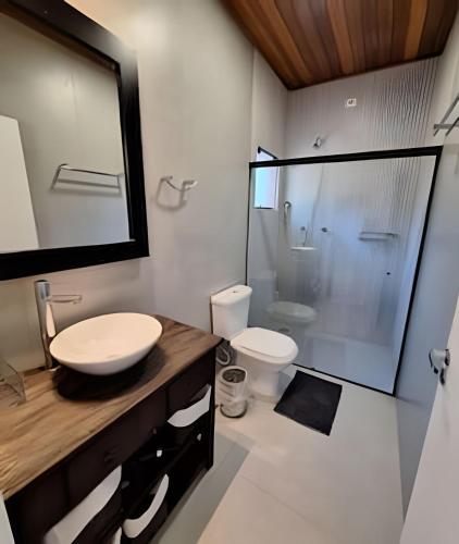 a bathroom with a sink and a shower and a toilet at Chalé Dália - Recanto Veky in Campos do Jordão