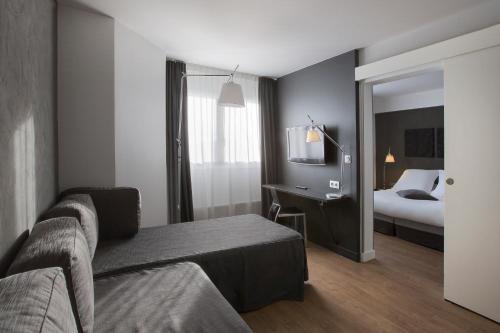 a hotel room with a couch and a bed at Hotel Litteraire Alexandre Vialatte, BW Signature Collection in Clermont-Ferrand