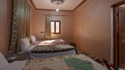 a room with two beds and a window at Dar Arghen Family Lodge in Imlil