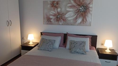 a bedroom with a bed with two lamps on it at Great apartment Katarina in Zadar