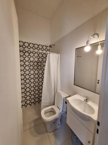 a bathroom with a white toilet and a sink at Casa Alba in San Salvador de Jujuy