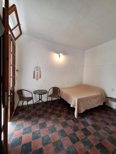 a room with a bed and two chairs and a table at Casa Alba in San Salvador de Jujuy