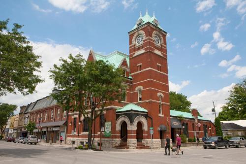 a large brick building with a clock tower on a street at Holiday Inn Express - Strathroy by IHG in Strathroy
