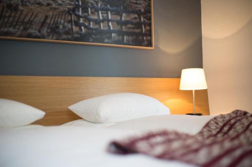 1 dormitorio con 2 camas blancas y cabecero de madera en Piltriquitron Lodging, en Sankt Anton am Arlberg