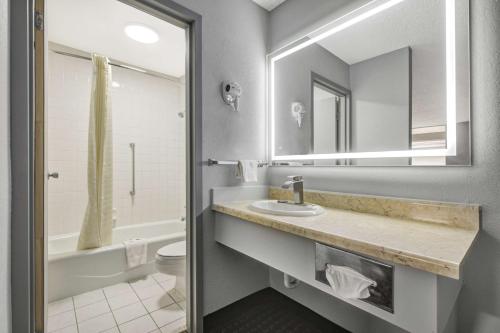 a bathroom with a sink and a toilet and a mirror at Motel 6 Chickasha, OK in Chickasha