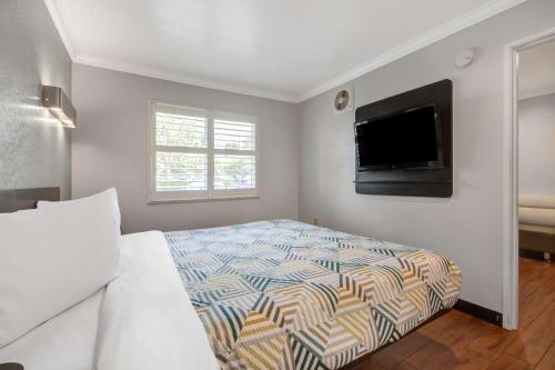 a bedroom with a bed and a flat screen tv at Motel 6 Ontario CA Convention Center Airport in Ontario