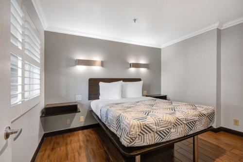 a bed in a room with two lights on the wall at Motel 6 Ontario CA Convention Center Airport in Ontario
