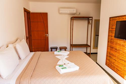 a hotel room with a bed with towels on it at Morena Jambo in Arraial d'Ajuda