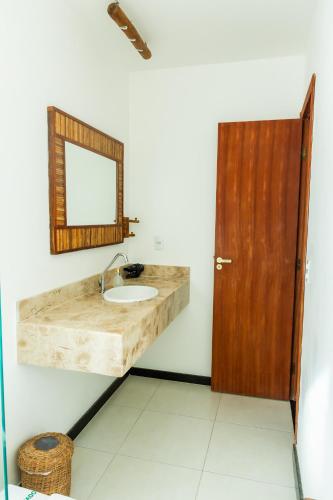 a bathroom with a sink and a mirror at Morena Jambo in Arraial d'Ajuda