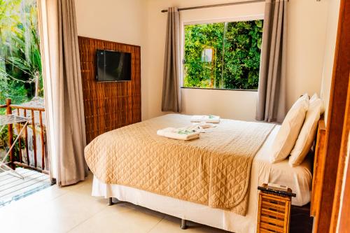 a bedroom with a bed and a window at Morena Jambo in Arraial d'Ajuda