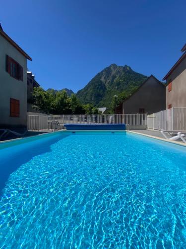 a large swimming pool with a mountain in the background at T2 bis 40M2 5P. Vue. Balcon. Parking. Piscine été. in Cauterets