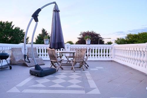 a patio with an umbrella and two chairs and a table at Harmony in Fleninge