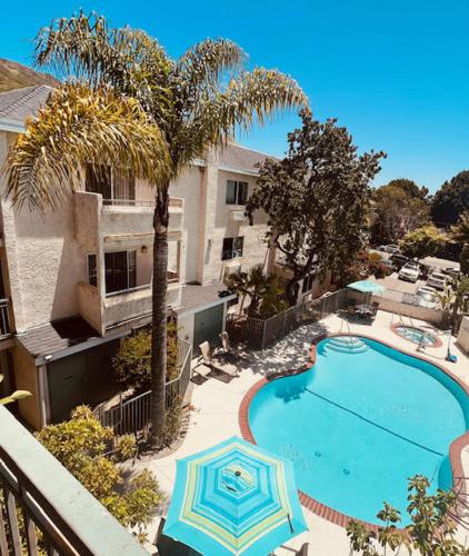 a swimming pool with an umbrella next to a building at Hotel Buena Vista - San Luis Obispo in San Luis Obispo