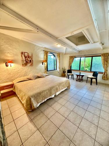 a bedroom with a large bed in a room with windows at Jean's Home in Puerto Ayora