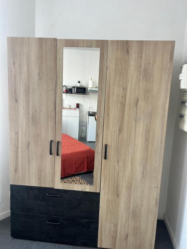 d'une grande armoire en bois avec un miroir. dans l'établissement Cosy Cannes Studio, à Cannes