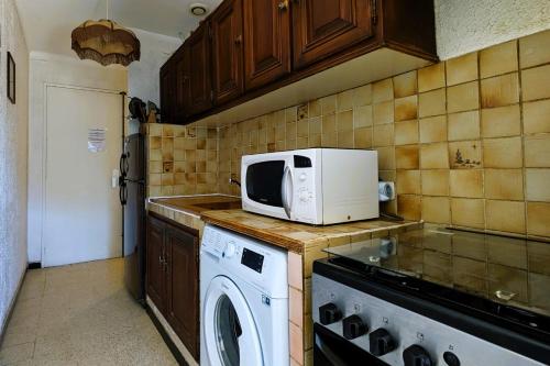 une cuisine avec un lave-linge et un four micro-ondes sur le comptoir dans l'établissement Nice T2 with terrace in Saint-Cyr-sur-Mer, à Saint-Cyr-sur-Mer