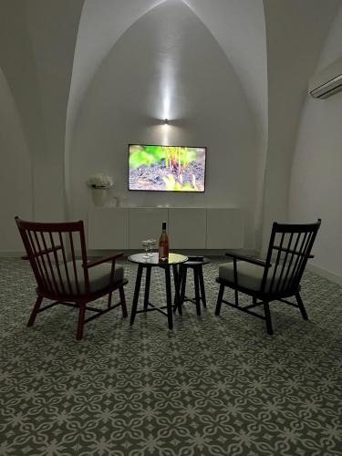 a room with two chairs and a table and a tv at Palác Daun - Studio Apartments in Znojmo