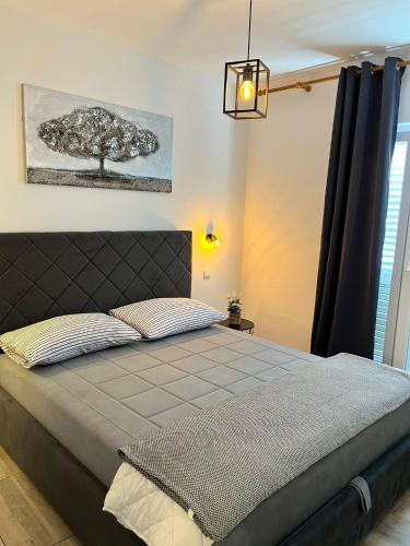 a bedroom with a bed with a tree on the wall at Apartment Potocnica 222a in Novalja