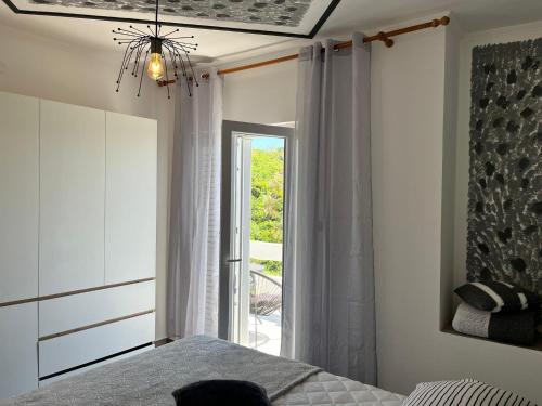 sypialnia z łóżkiem i dużym oknem w obiekcie Apartment Potocnica 222d w Novalji