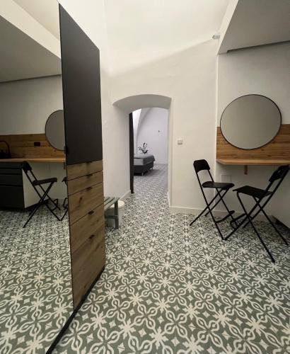 a room with two mirrors on the wall and chairs at Palác Daun - Studio Apartments in Znojmo
