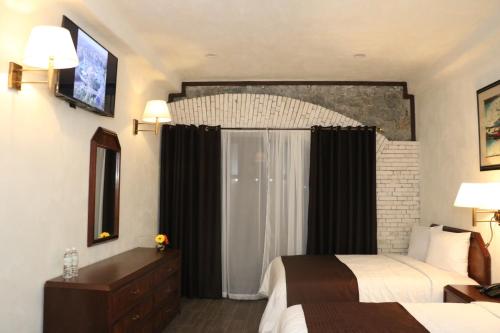 a hotel room with two beds and a window at SANTA CECILIA LA MORA HUASCA in Huasca de Ocampo