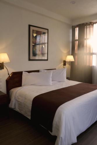 a large bed in a hotel room with two lamps at SANTA CECILIA LA MORA HUASCA in Huasca de Ocampo