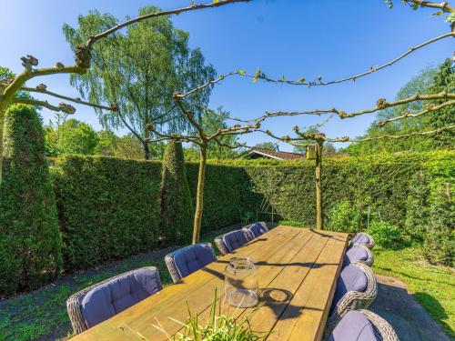 a wooden table and chairs in a garden at De 5 Platanen in Hulshorst