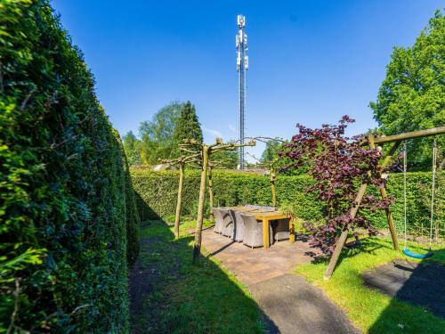 a garden with a table and some bushes at De 5 Platanen in Hulshorst