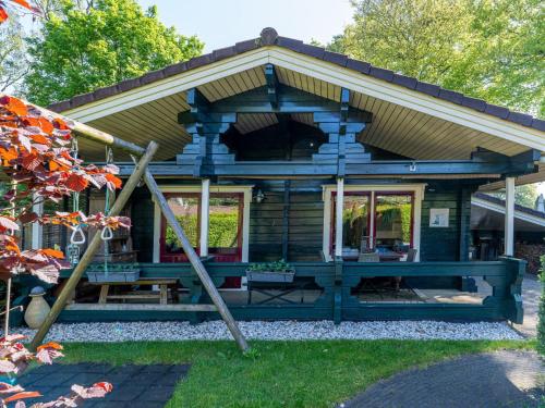 a log cabin with a porch and windows at De 5 Platanen in Hulshorst