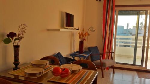 a living room with a dining room table and a dining room at Charming with Sea View in Monte Gordo