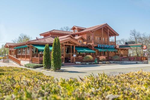a large wooden building with a restaurant at MeDoRa Park - Hotel MeDoRa*** in Gárdony