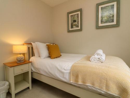 ein Schlafzimmer mit 2 Betten und einem Nachttisch mit einer Lampe in der Unterkunft Swallow Cottage in Ilfracombe