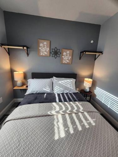 a bedroom with a large bed with two lights on it at Green Roof House Studio in Lakeland