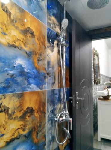 bagno con doccia e dipinto sul muro di Bumbo Apartment a Hanoi