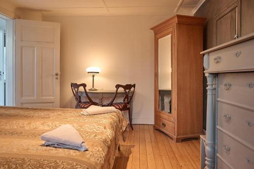 a bedroom with two beds and a table with a lamp at Harmony in Fleninge
