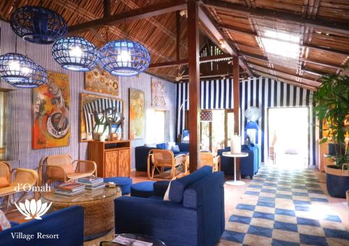 a living room with blue furniture and chandeliers at D'omah Yogya Hotel in Yogyakarta