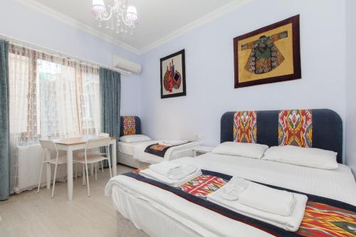 イスタンブールにあるSUFI Apartのベッド2台とテーブルが備わるホテルルームです。
