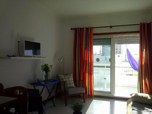 a living room with a sliding glass door to a balcony at Charming with Sea View in Monte Gordo