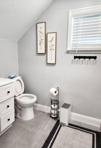 a bathroom with a toilet and two pictures on the wall at Green Roof House in Lakeland