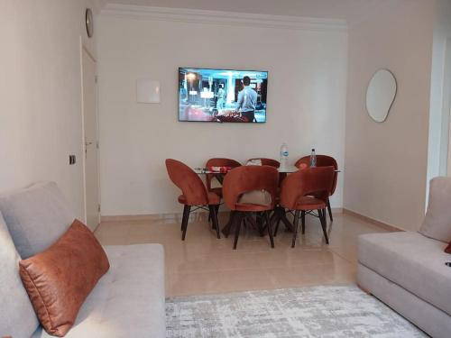 a living room with a dining room table and chairs at Appartement Cœur de Khouribga in Khouribga