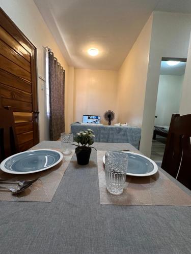 a table with plates and glasses on top of it at Modern 1-bedroom Apartment with Full-Bed in Sibulan