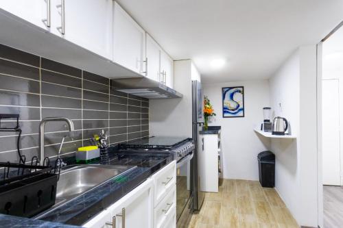 a kitchen with a sink and a refrigerator at Private Room #3 in a 4 bedroom Guest House in Roma Norte, Mexico City in Mexico City
