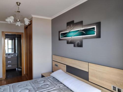 カマリーニャスにあるApartamento O Pesquiñoの木製のヘッドボードが付いたベッドのある寝室