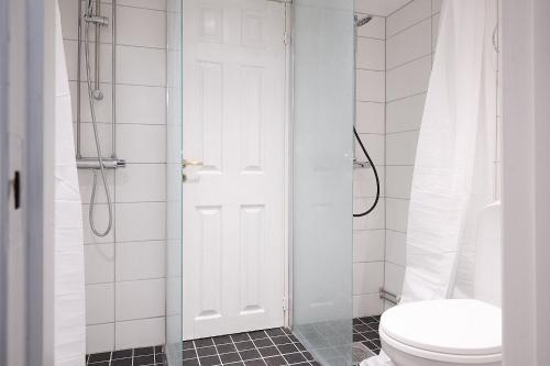 a white bathroom with a toilet and a shower at Harmony in Fleninge