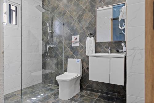 a bathroom with a toilet and a sink and a shower at Hotel Vista Caribe Azúa in Azua de Compostela