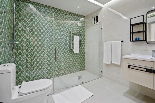 a bathroom with a shower and a toilet and a sink at Hotel Vista Caribe Azúa in Azua de Compostela