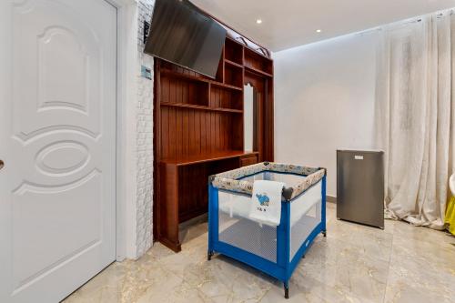 a room with a tv and a blue ottoman at Hotel Vista Caribe Azúa in Azua de Compostela