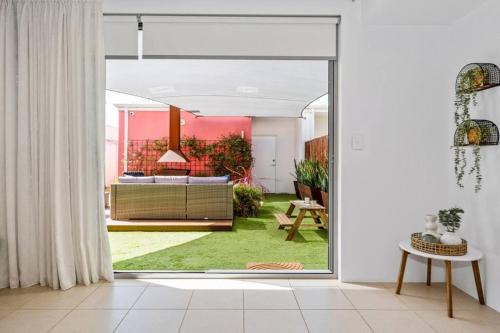 a living room with a door open to a living room at Seaside Beach House, luxury 3x2, fire pit, secure garden, pet friendly, sleeps 8, opp cafe in Mandurah