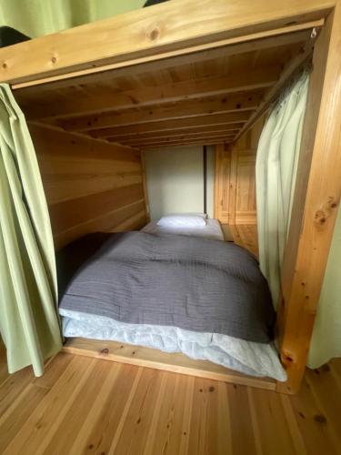 a small bed in a tiny house at 安曇野ふくろうハウス 1組限定の宿 in Hotaka